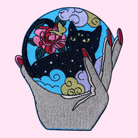 Hand holding cat embroidery patch